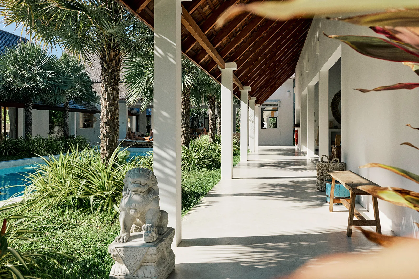A stone guardian statue among the garden palms
