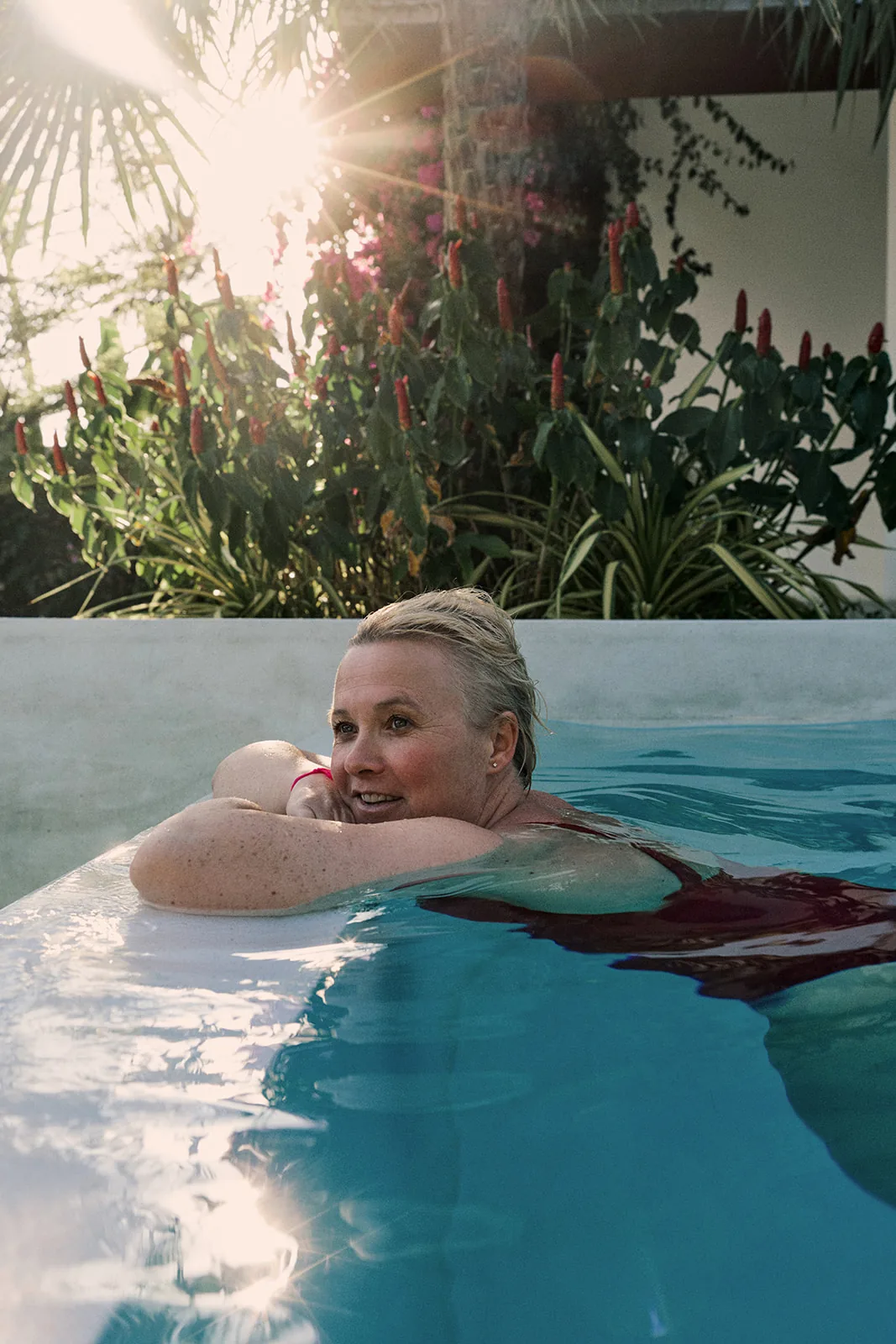 Relaxing at the edge of the pool as sunlight filters through the palms