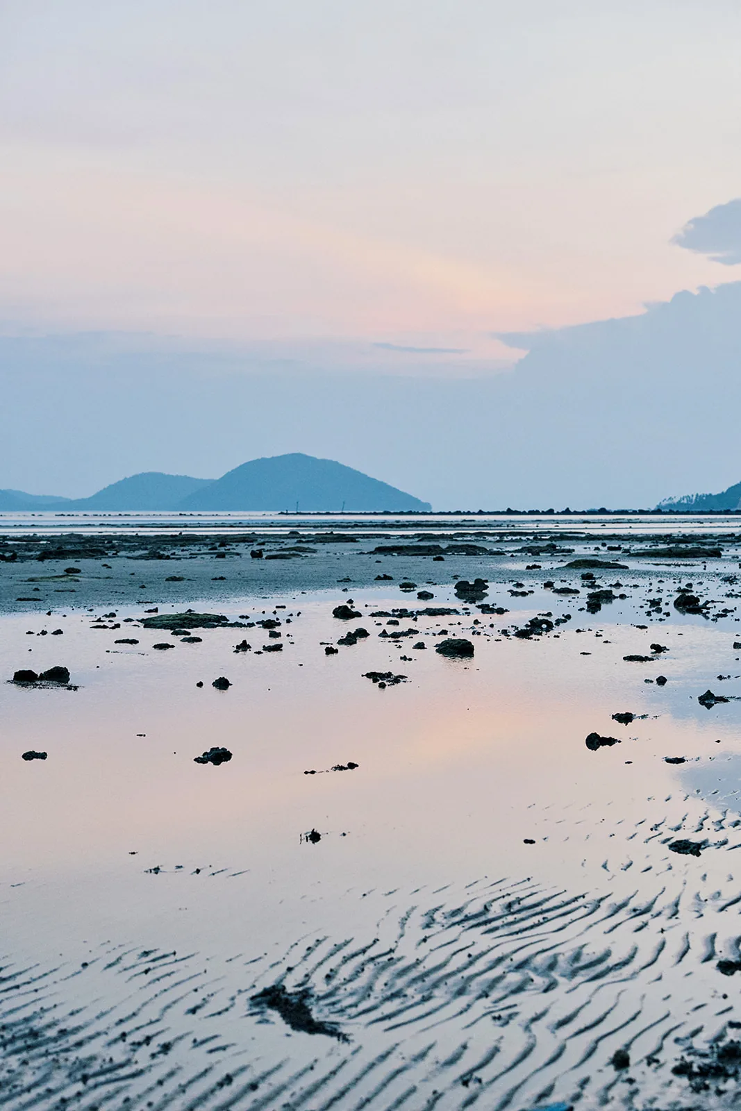 Sunset reflections across the wet sand at low tide