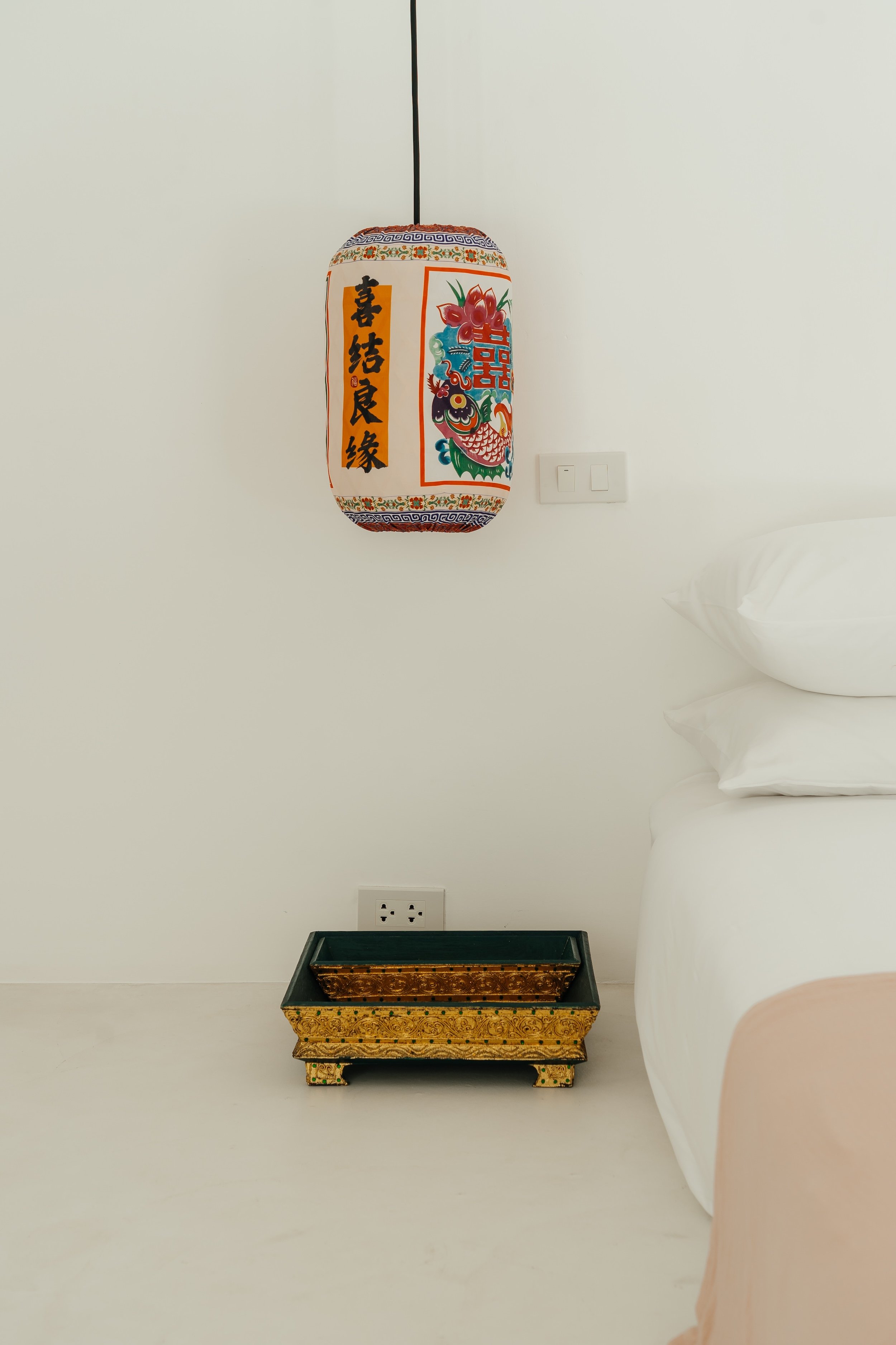 Bedside table with warm lamp and curated details in Villa Aditi bedroom, Koh Samui