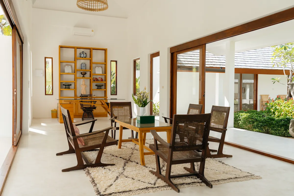 Air-conditioned library lounge with writing desk, display cabinet, and courtyard view at Villa Aditi, Koh Samui