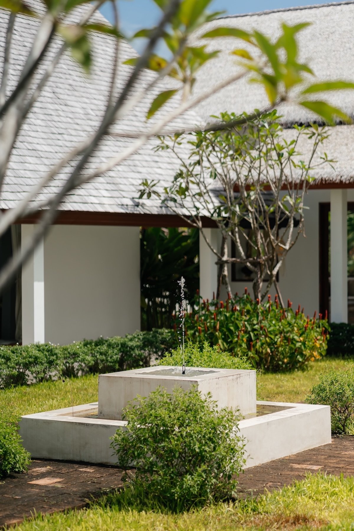 Stone courtyard fountain surrounded by tropical plants at Villa Aditi, Koh Samui
